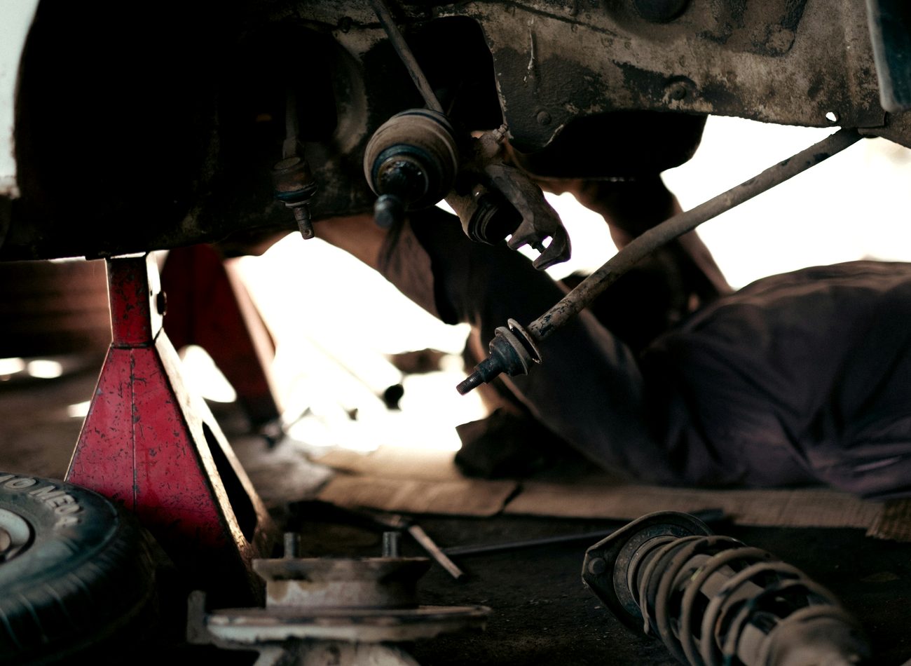Underneath a car during a suspension repair on the workshop floor